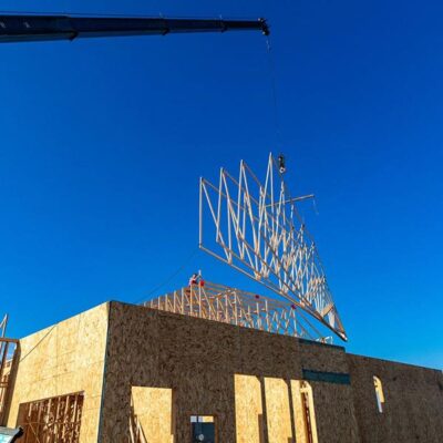 Roof trusses being installed with a crain